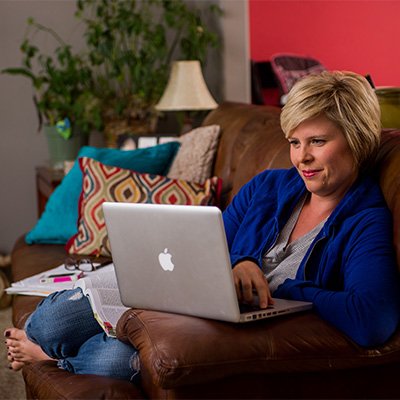 CDE student studying on a couch in her living room