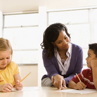 Teacher sitting with two students.