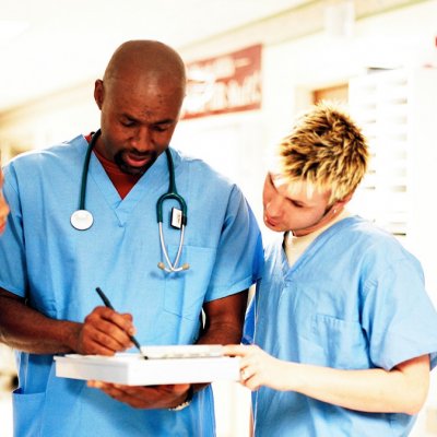 Nurses in hallway looking at a chart.