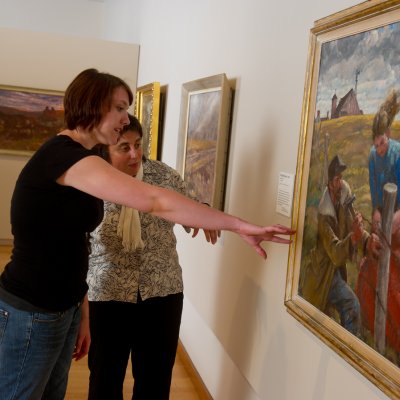 Student and professor looking at a painting in the SD Art Museum.