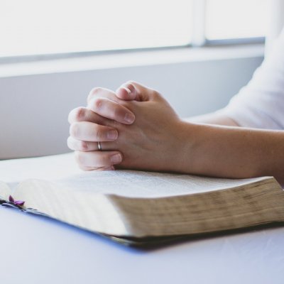 View of individual holding their hands in prayer.