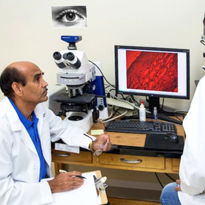 Associate professor Chandrasekher, left, talking to doctoral student Somshuvra Bhattacharya with image of human cornea cross-section on computer screen between them