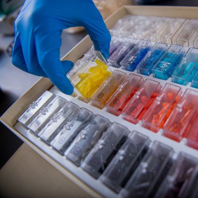 gloves hand picking up container with yellow pills