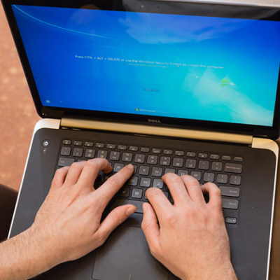 Hands typing on a laptop