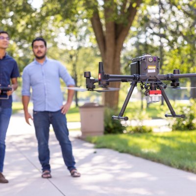 View of two individuals flying a drone.