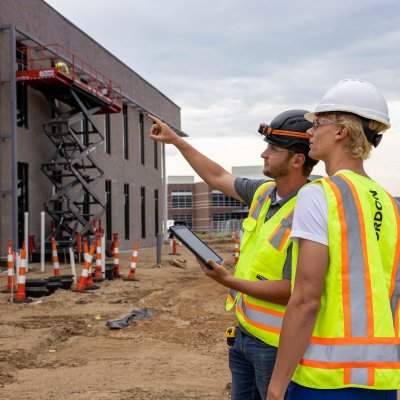 Two individuals looking at a construction jobsite.