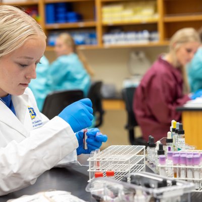 A student doing pharmacy research with test tubes.