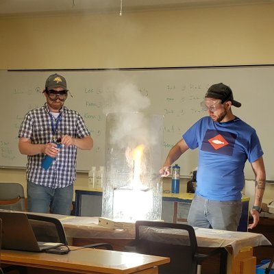 Teachers standing at the front of a classroom showing an experiment.