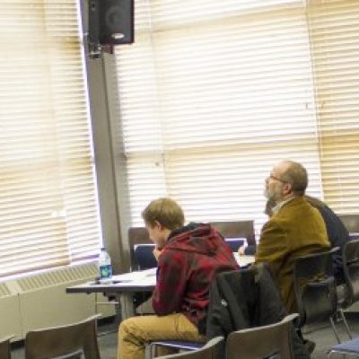 A judge sitting in a classroom watching a documentary at National History Day.