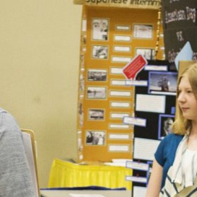 Students presenting their exhibit to 2 judges at National History Day.