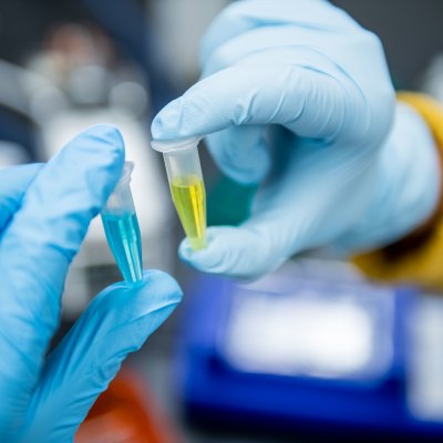 researcher holding centrifuge tubes