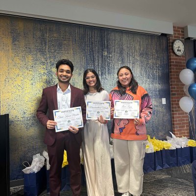 Three students smiling and holding certificates