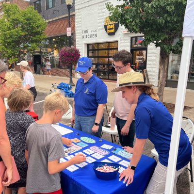 Staff members guiding community members through a matching activity at Downtown at Sundown