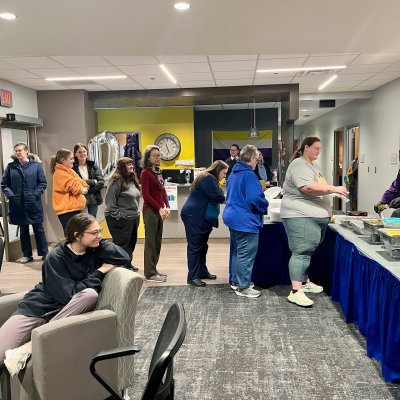 People standing and waiting in a line to be served food buffet style