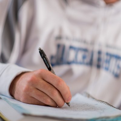 Student writing in a notebook.