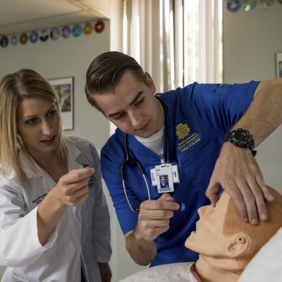 student and professor in simulation lab