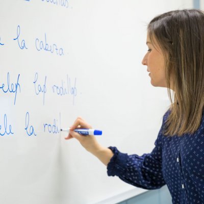 Instructor is writing on the board in Spanish