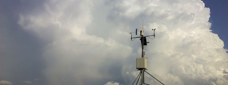 Mesonet station with cumulonimbus and rainbow