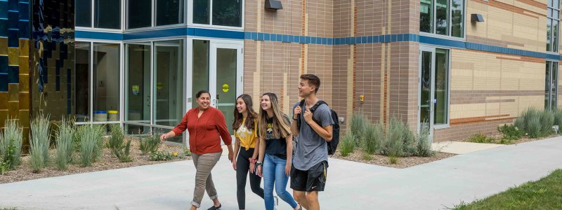 Students walking with. faculty member outside of AISC