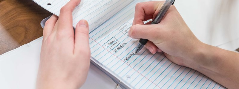 close up image of hands and a notebook 