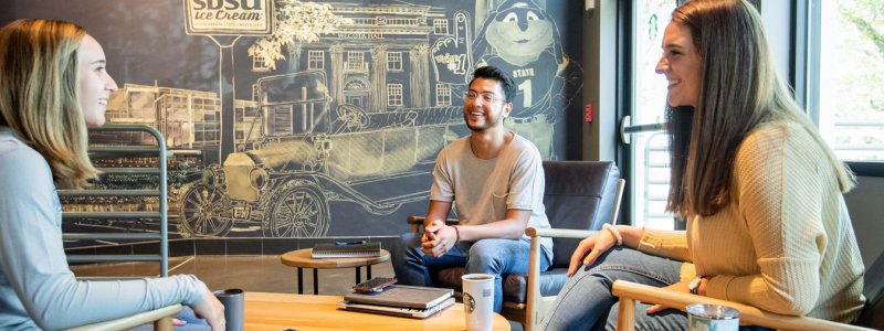 3 students conversing at the Starbucks on campus