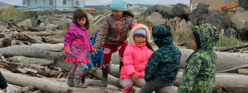 Children sitting on logs