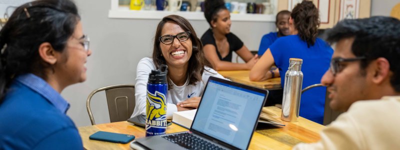 Three students sitting at a table studying together.