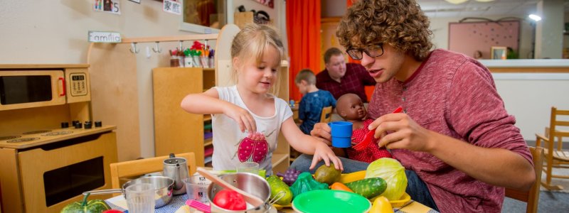 Teacher and student playing with colorful toys