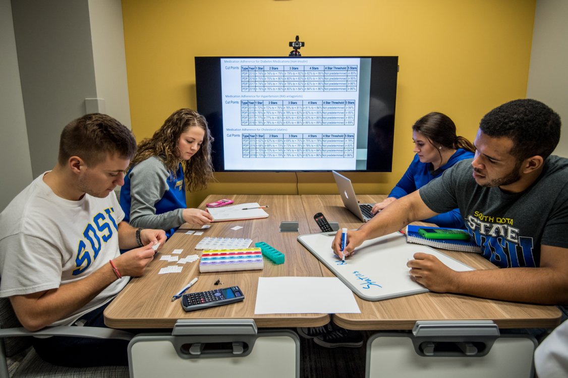 Pharmacy students in small group learning space