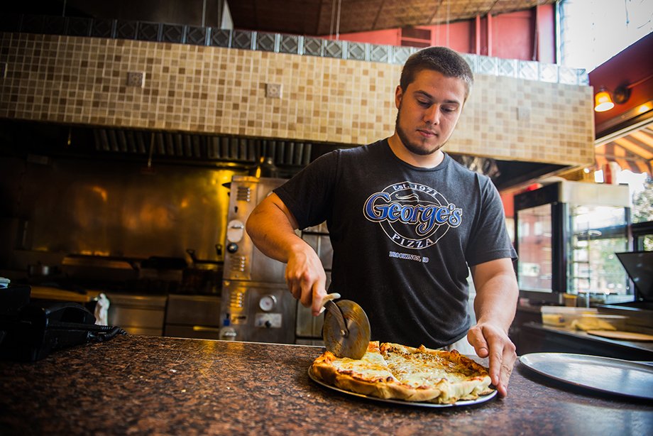 Cutting a pizza at George's Pizza