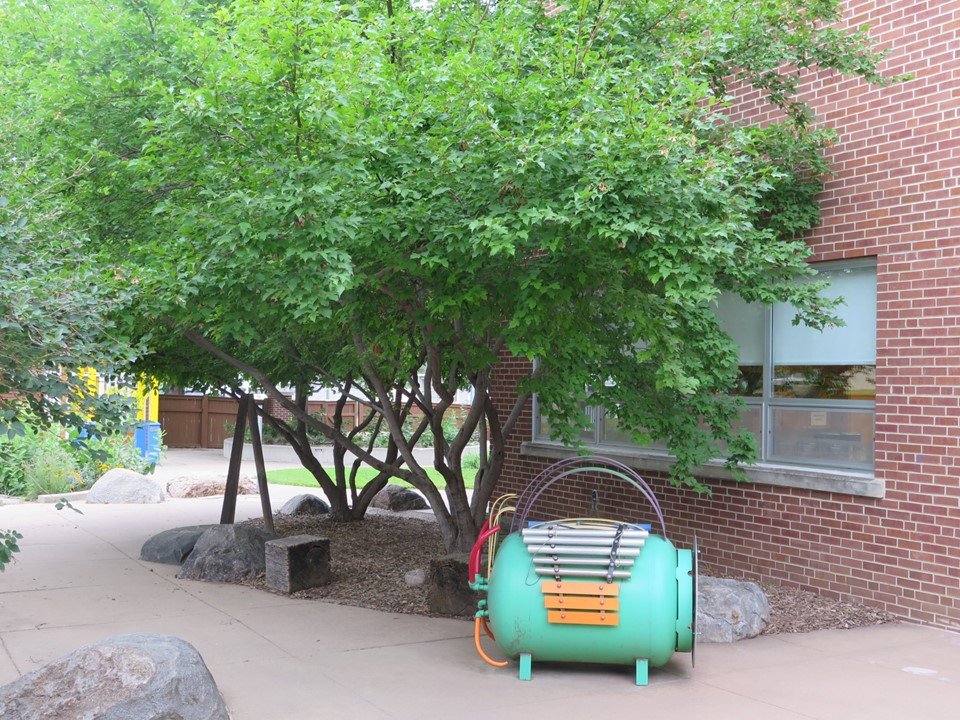 The dinosaur musical chime out in the playground next to the climbing trees.