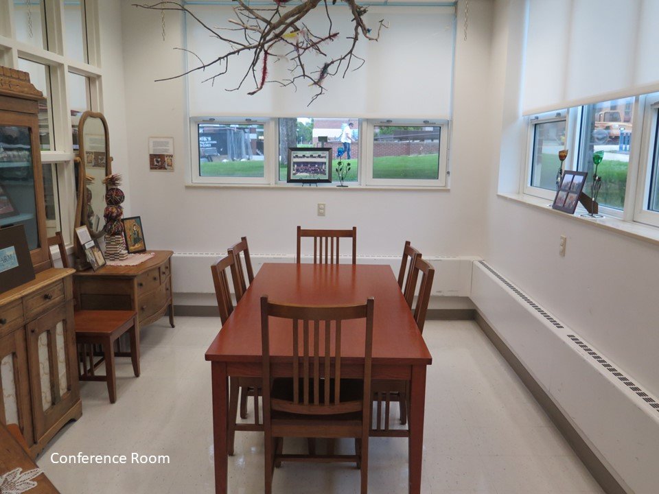 The conference room that includes a large table with chairs around it.