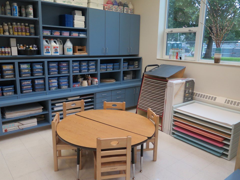 A table in the art studio next to the oil pastels, chalk and other writing utensils.