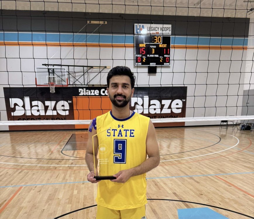 NAFNU Akshit holding a memento for winning volleyball competition.