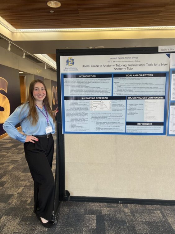 Kennedy Roland standing next to her poster "A User's Guide to Anatomy Tutoring".