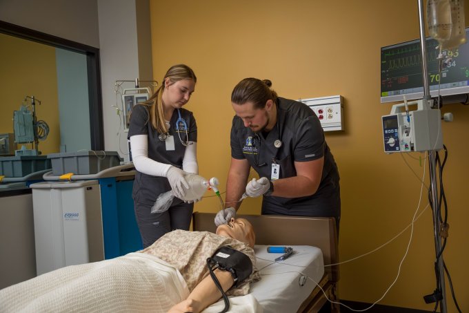 Respiratory care students and a mannequin.