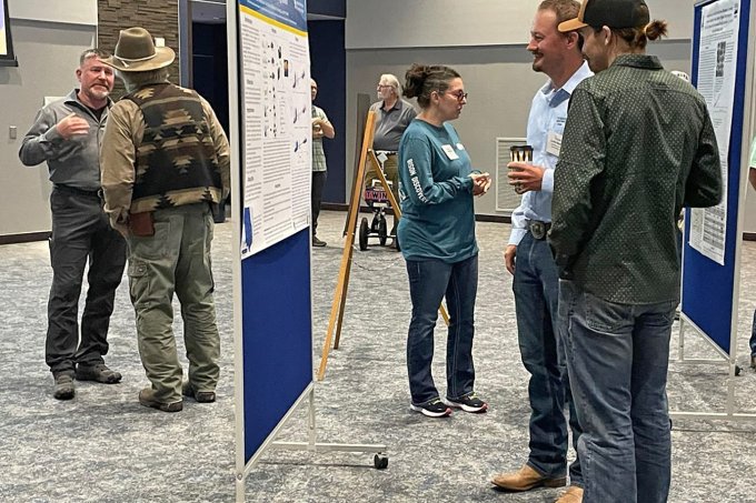 Symposium attendees enjoy catching up during a break in the presentations. Many chose to browse through the student research posters during the break.