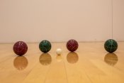 2 red and 2 green bocce balls with 1 white ball in the middle