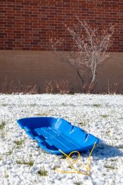 Blue snow sled on a snow covered ground