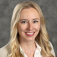 Portrait of Sarah Sellars in a white shirt and gray background