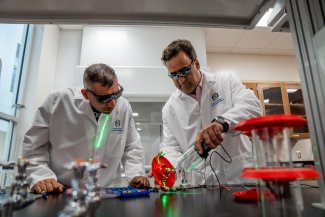 A student and professor performing an experiment.