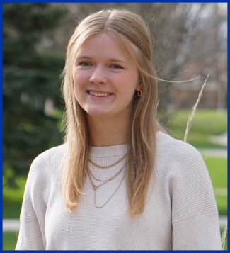 Student's Association College of Agriculture, Food, and Environmental Sciences senator Grace Peterson sitting on a bench outside smiling
