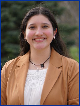 Student's Association College of Natural Sciences senator Victoria Vazquez sitting on a bench outside smiling